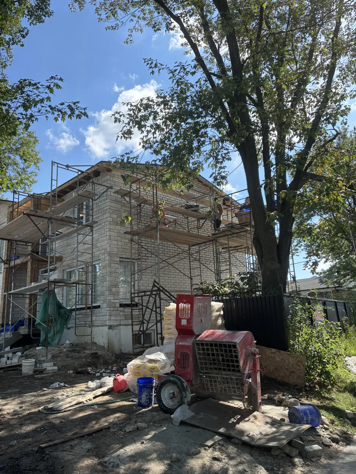 Chantier de maçonnerie avec échafaudage et bétonnière
